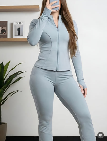 Conjunto deportivo que incluye chaqueta de manga larga con cremallera y pantalones.